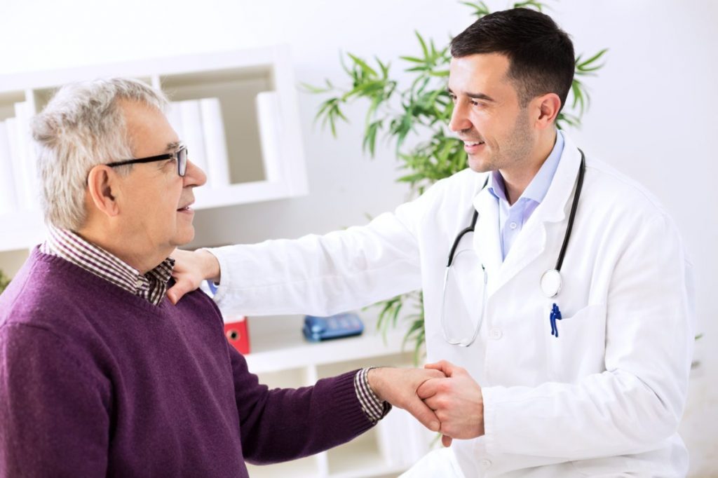 A doctor shaking the hand of an elderly patient